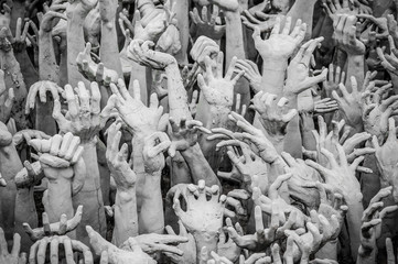 Fototapeta na wymiar Sculpture of hundreds outreaching hands. White Temple, Chiang Rai Thailand