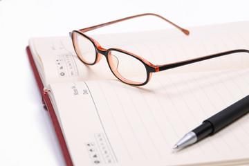 Glasses and pen with open planner