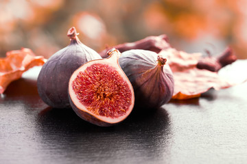 Closeup on fresh figs on dark shiny stone plate outdoors
