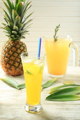 Icy fresh cocktail with pineapple in glass on light wooden background