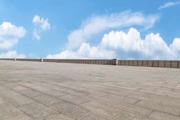Empty stone floor under blue sky and white clouds