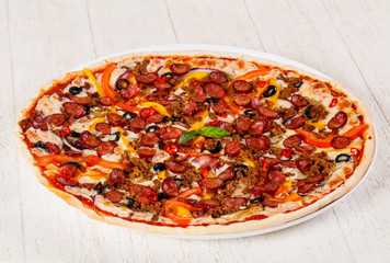 Pizza with sausages and minced meat
