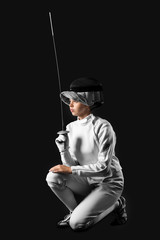 Young female fencer on dark background