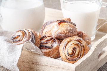 Side view of a white breakfast tray with milk in glass jar, croissants