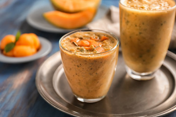 Glasses of tasty melon smoothie on wooden table