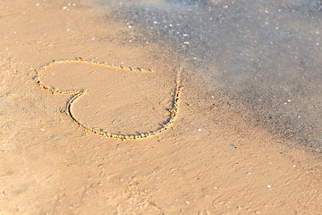 Fototapeta na wymiar Heart drawn on beach sand