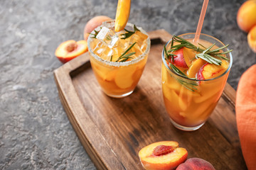 Glasses of tasty cold cocktails on wooden board