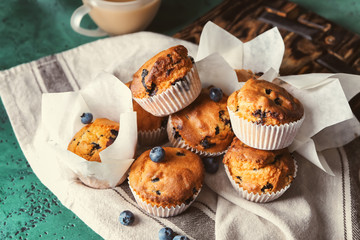 Tasty blueberry muffins on color table