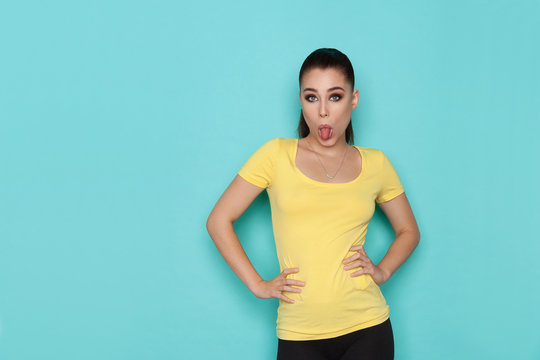 Young Woman In Yellow Shirt Is Sticking Out Tongue