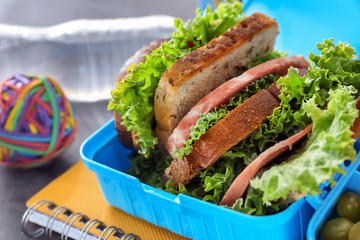 Lunch box with appetizing food on table