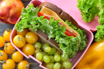 Lunch box with appetizing food on table