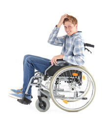Young man sitting in wheelchair on white background
