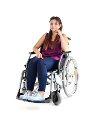 Young woman sitting in wheelchair on white background