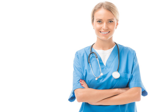 happy young nurse with crossed arms looking at camera isolated on white