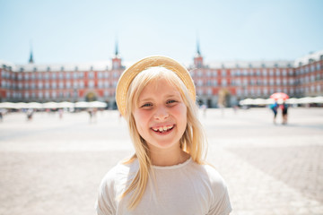 happy child in straw hat at Plaza Mayor in Madrid, Spain