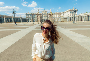 Naklejka premium szczęśliwa nowoczesna kobieta turystycznych w pobliżu Pałacu Królewskiego w Madrycie, Hiszpania