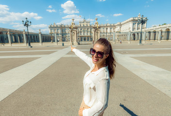 Obraz premium kobieta w pobliżu Pałacu Królewskiego w Madrycie, Hiszpania, wskazując na coś