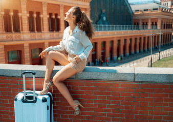 woman near Puerta de Atocha in Madrid, Spain sitting on parapet