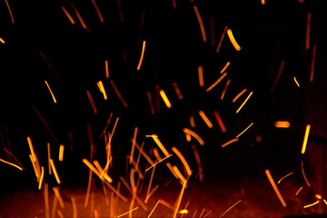 Fire sparks in the air near the fireplace defocused