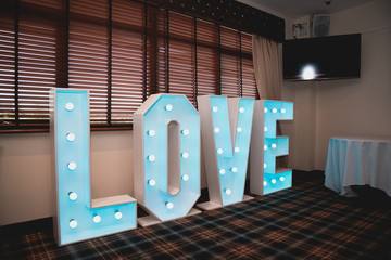 Big blue illuminated love letters on a wedding day