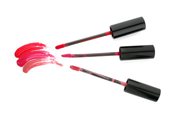 Different liquid lipsticks with strokes on white background