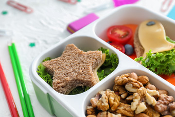 Lunch box with appetizing food on table