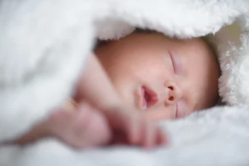 Fototapeten Newborn baby boy portrait on white carpet closeup. Motherhood and new life concept © Ivan Kmit