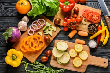 Fotobehang Cutting boards and many fresh vegetables on wooden background © Pixel-Shot