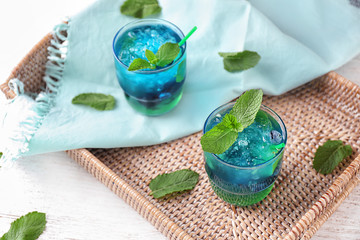 Glasses of refreshing summer cocktail on wicker tray