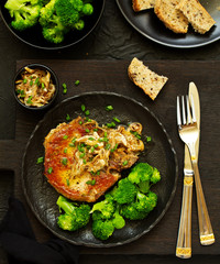 Fried pork steak with broccoli and onion sauce.