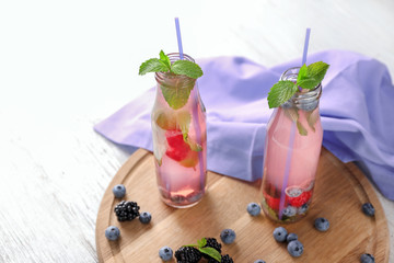 Bottles of refreshing summer cocktail on wooden board
