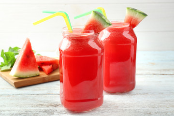 Jars of fresh watermelon lemonade on wooden table