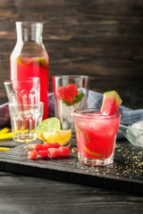 Glass of fresh watermelon lemonade on wooden board