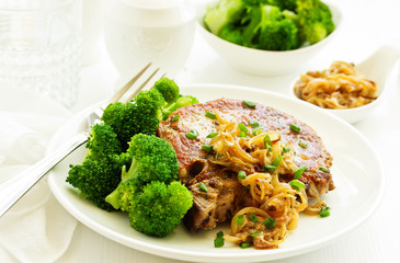 Fried pork steak with broccoli and onion sauce.