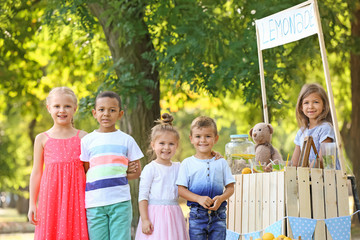 Happy children near lemonade stand in park