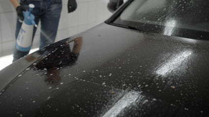 Fototapeta premium Man washing car in carwash station.