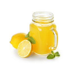 Mason jar of fresh lemon juice on white background