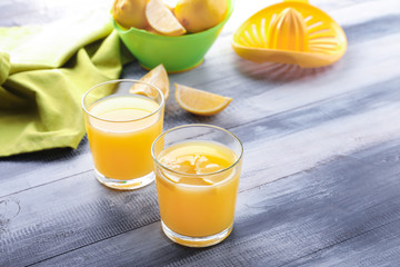 Glasses of fresh lemon juice on wooden table