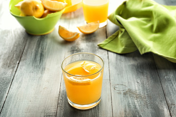 Glass of fresh lemon juice on wooden table