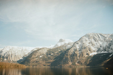 Beautiful Alpine mountains on the other side of the lake near Hallstatt. White summits beneath blue skies. View from the lakeside. Film photography
