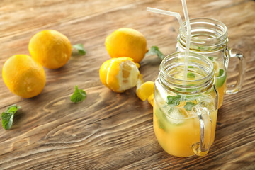 Mason jars of fresh lemon juice on wooden table