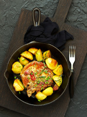 Fried pork steak with vegetables and potatoes.