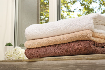 Obraz na płótnie Canvas Stack of clean soft towels on windowsill indoors