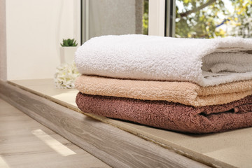 Fototapeta na wymiar Stack of clean soft towels on floor indoors