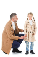 stylish father and daughter in beige autumn coats, isolated on white