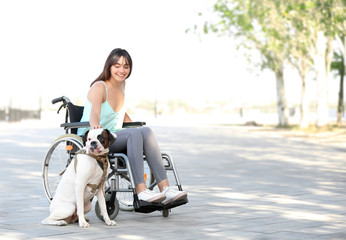 Young woman in wheelchair and her service dog outdoors