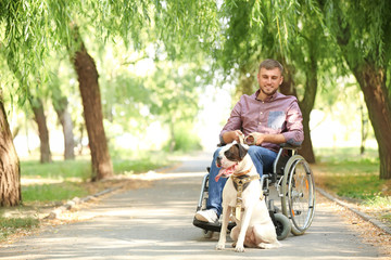 Young man in wheelchair and his service dog outdoors