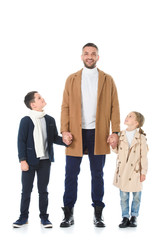 happy father holding hands with siblings in autumn outfit, isolated on white