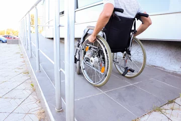Fotobehang Young man in wheelchair on ramp outdoors © Pixel-Shot