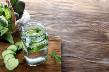 Jar of cucumber infused water on wooden table